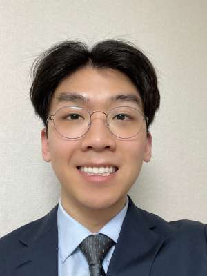Smiling person in suit and tie wearing glasses