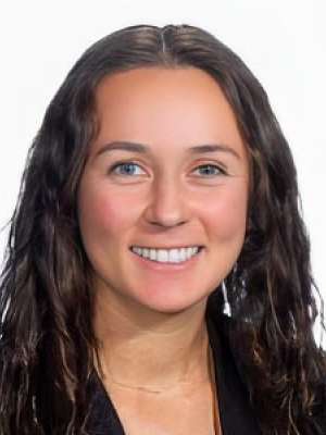 Natalie Kennedy headshot, smiling with dark wavy hair