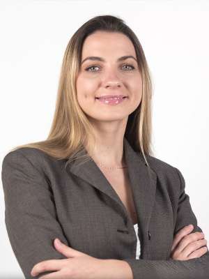 Headshot of Tatiana Diacova wearing a grey blazer