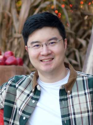Headshot of Xianghang wearing glasses and a green flannel shirt in the outdoors.
