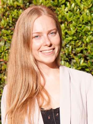 headshot of Rozeta Avetisyan with a bush plant in the background