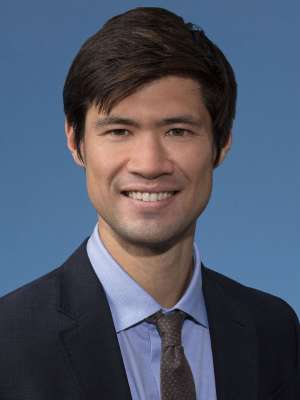 Smiling man in suit and tie on blue background