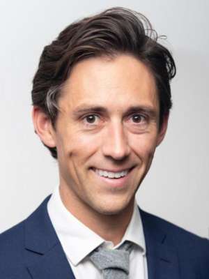 headshot of Nicholas Peterson in dark blue suit