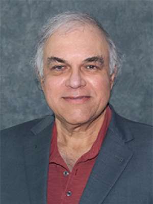 headshot of Dr. Jose Escarce in a grey suit and burgundy shirt