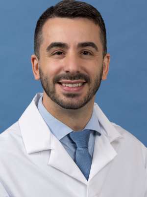 White coat head shot of Borja Sanz Cuesta, smiling at the camera