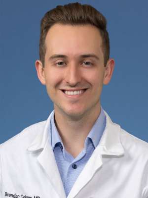 Head shot of Brendan Colgan MD, in white coat, smiling at camera