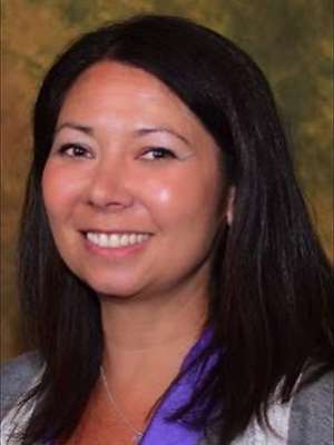 headshot of Dr. Resa Oshiro in front of brown backdrop