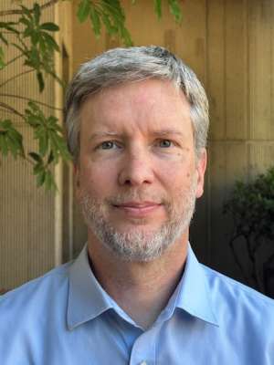 Head-and-shoulders portrait of person in blue shirt