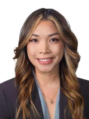 Smiling professional woman in blazer with long highlighted wavy hair and necklace