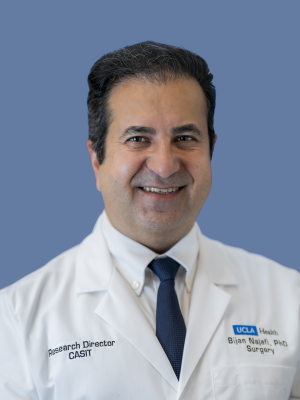 Dr. Bijan Najafi, PhD, wearing a white UCLA Health lab coat and smiling against a blue background.