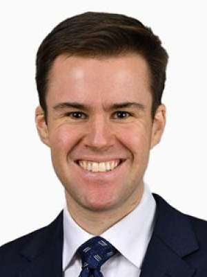 Smiling man wearing suit and tie headshot