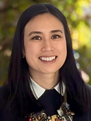 Dr. Hsue with long black hair wearing a dark outfit stands outdoors.