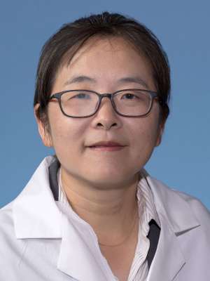 Yuan Shui, MD, PhD in a white lab coat
