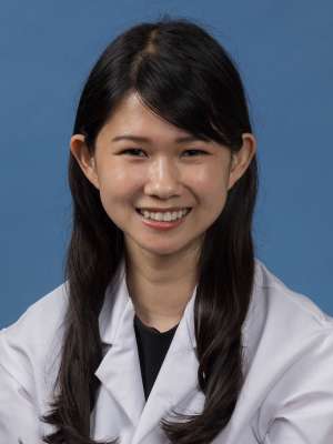 Head shot of Edith Yuan in white lab coat, smiling at camera