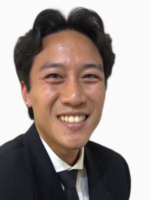 Brett Muramoto smiling headshot in suit and tie