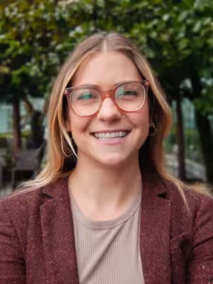 Catherine Meyer with blonde hair and glasses wearing a burgundy cardigan and smiling outdoors