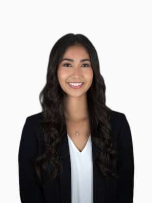 Smiling professional woman in black blazer and white blouse on white background