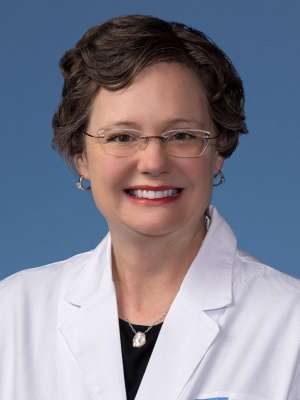 Michelle Hickey, PhD, in a white lab coat