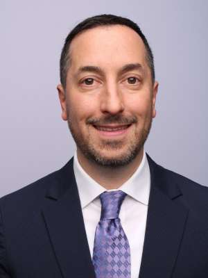 A man with short hair wearing a suit and tie