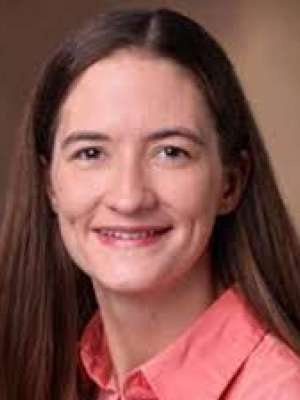 headshot of Carrie Wiese in a salmon colored shirt