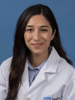 Head shot of Adrianna Carrasco in white lab coat, smiling at camera