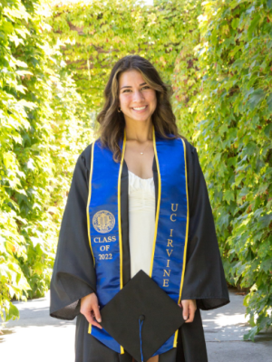 Scarlett, who is wearing a graduation cap and gown, and a blue graduation stole from University of California, Irvine