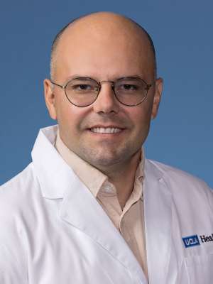 Imir Metushi, PhD in a white lab coat