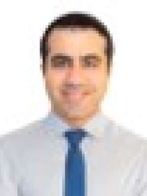 Head shot of Masoud Yaganegi in a dress shirt and tie, smiling at the camer.