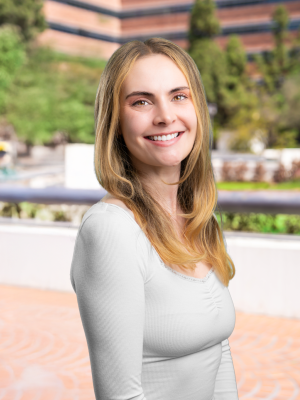 Madeline Haley in white top standing in an urban park plaza