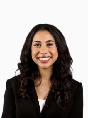 Jessica Gabra smiling headshot wearing dark blazer against white background