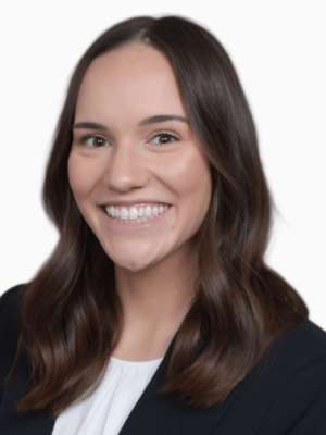 Headshot of smiling woman with dark hair wearing black blazer and white blouse