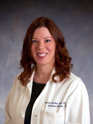 Jennifer A. Fulcher, MD, PhD in white lab coat, professional headshot