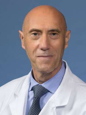 Nicola Longo, MD headshot wearing white coat, blue shirt and patterned tie