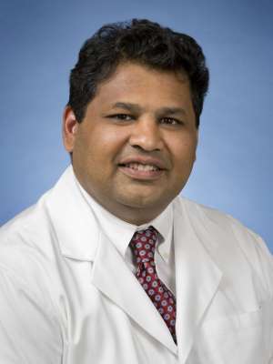 Raman Muthusamy, MD, MAS headshot wearing white coat and tie, smiling