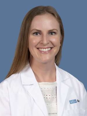 Headshot of Arissa Young, MD, in a white lab coat against a blue background.