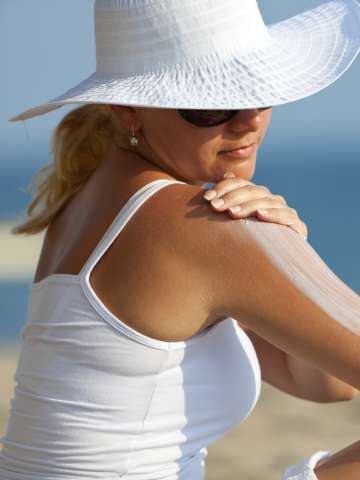 Woman applying lotion to shoulder
