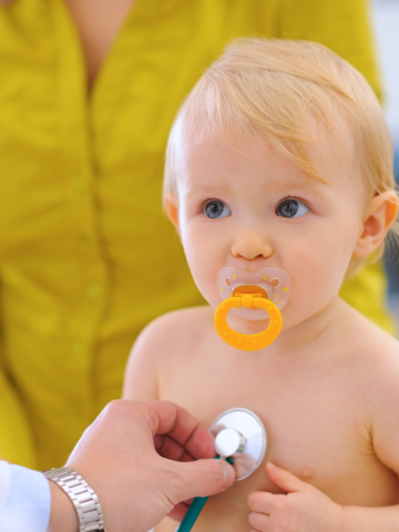 Doctor holds stethoscope to a baby's chest