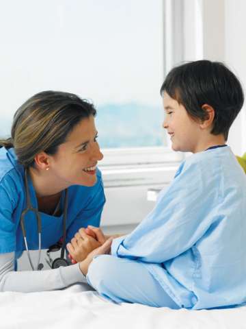 Doctor smiling with patient in hospital bed