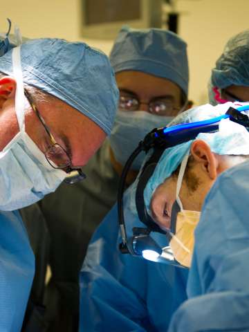 Four doctors in the operating room performing general surgery.