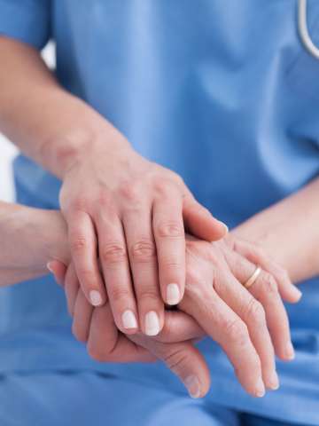 Close up of nurse touching the patient hand