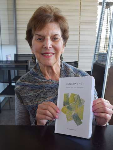 Ellen Cantor holds her poetry book