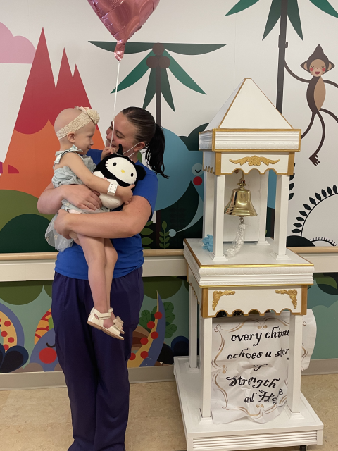 A Chase Child Life Specialist holds a young girl.