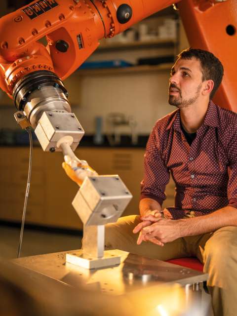 Man sits with robot arm