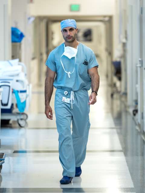 A surgeon walks through a hospital hallway.