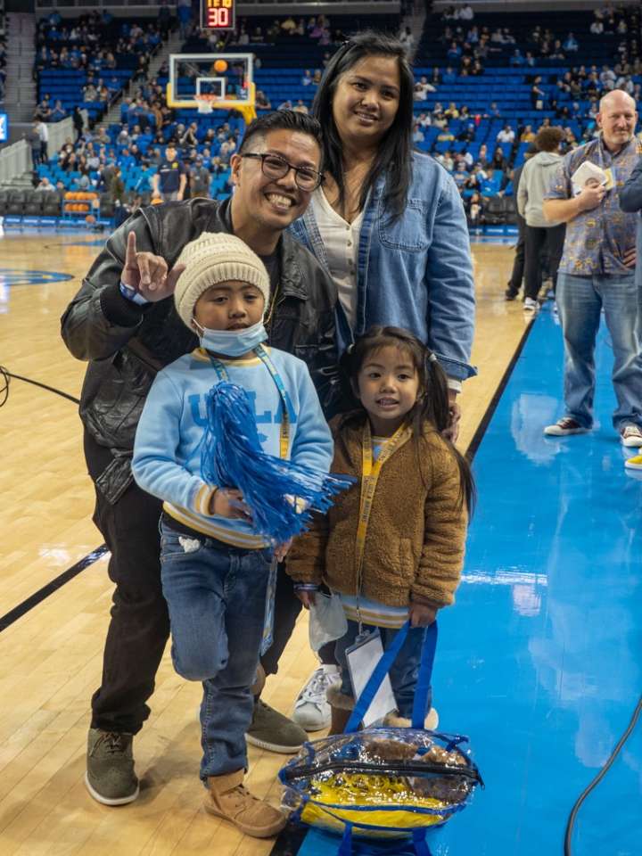 Rainen and Myla Valeriano and their parents, Art and Desiree, enjoy being on the court at a UCLA Men's Basketball game. (Photo by Catherine Boyer/UCLA Health)