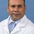 White coat head shot of Sabir Syed, giving a small smile at the camera