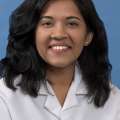 White coat head shot of Darshana Vijaywargiya, smiling at the camera