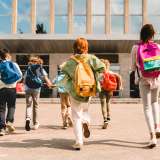 Children wearing backpacks running to school 