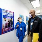 Clinical researcher Christopher Blades and laboratory coordinator Demetria Villanueva walk down a hallway of the Vine Street Clinic.