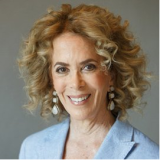 Headshot of Eileen Goodis-Strom behind a gray background.